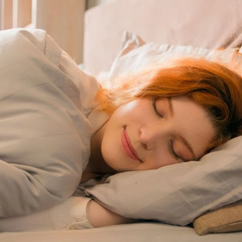 A woman asleep as morning light enters the room