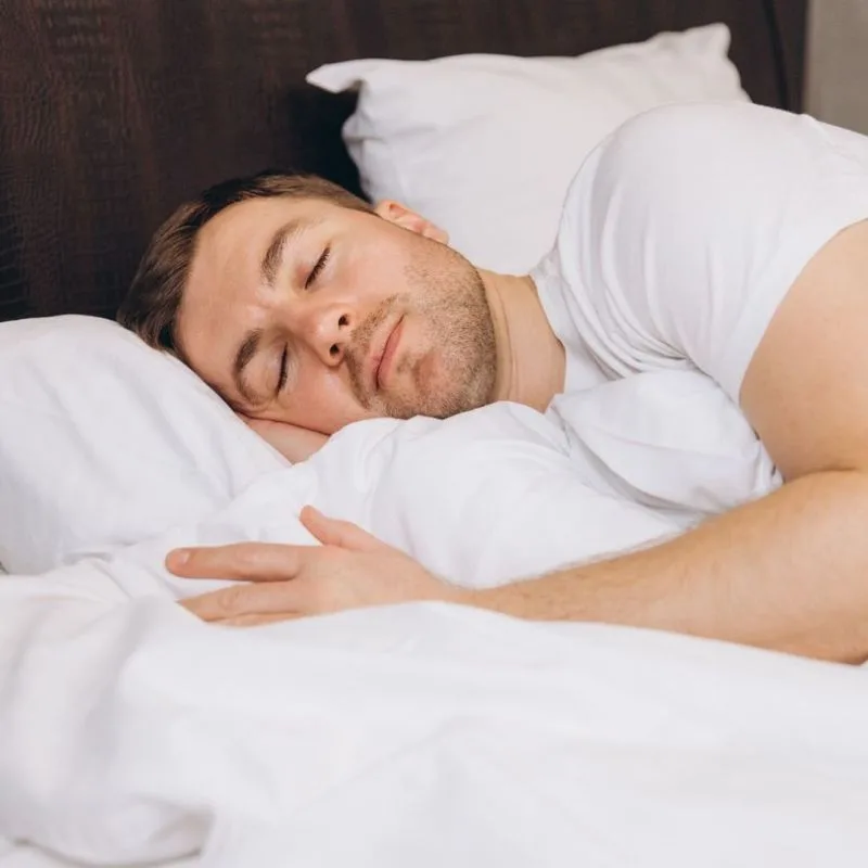 A man asleep in daylight, curtains partly drawn