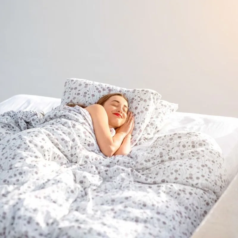 A woman waking in a sunlit bedroom